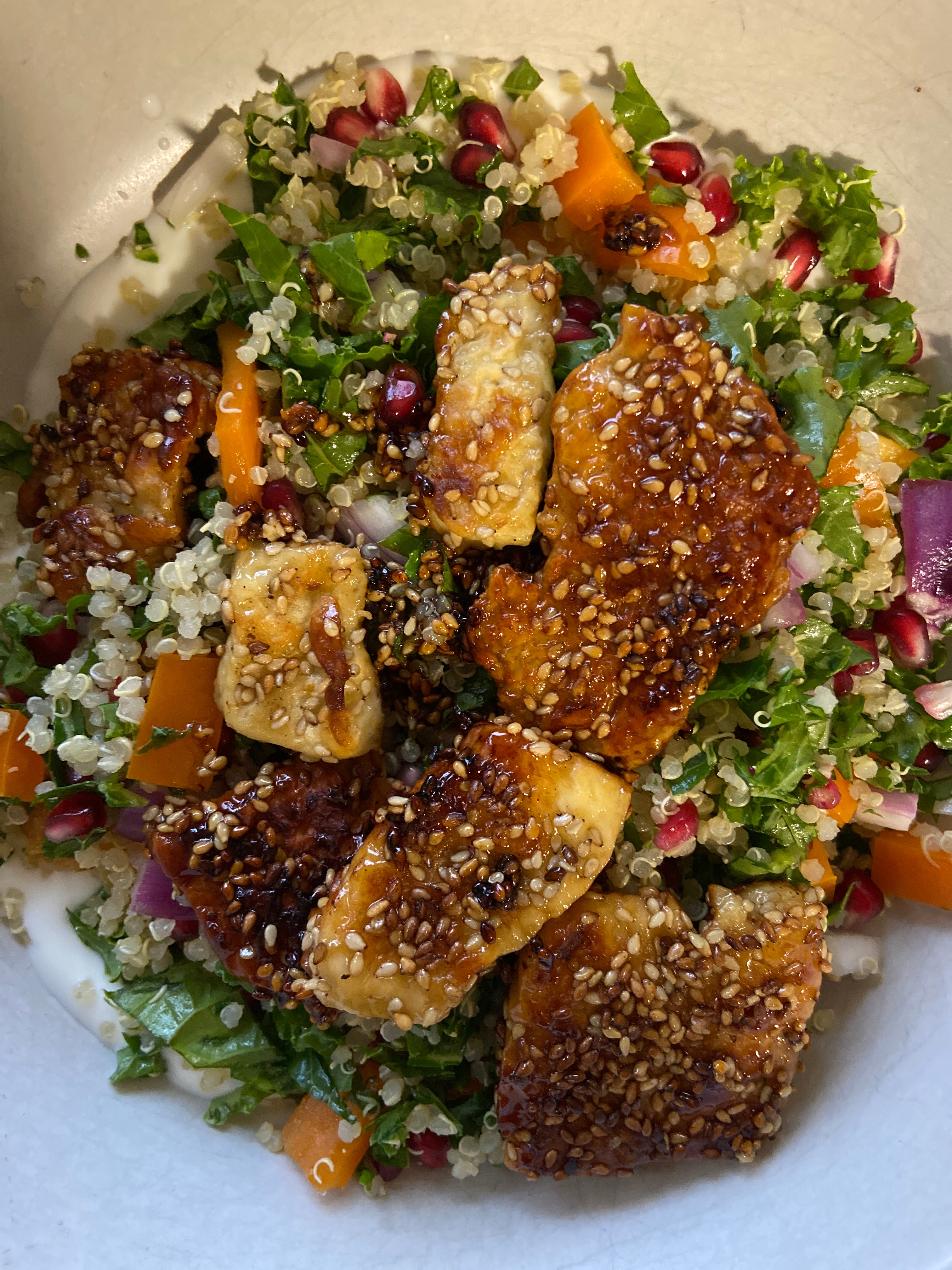 sesame coated halloumi sits on a bed of salad