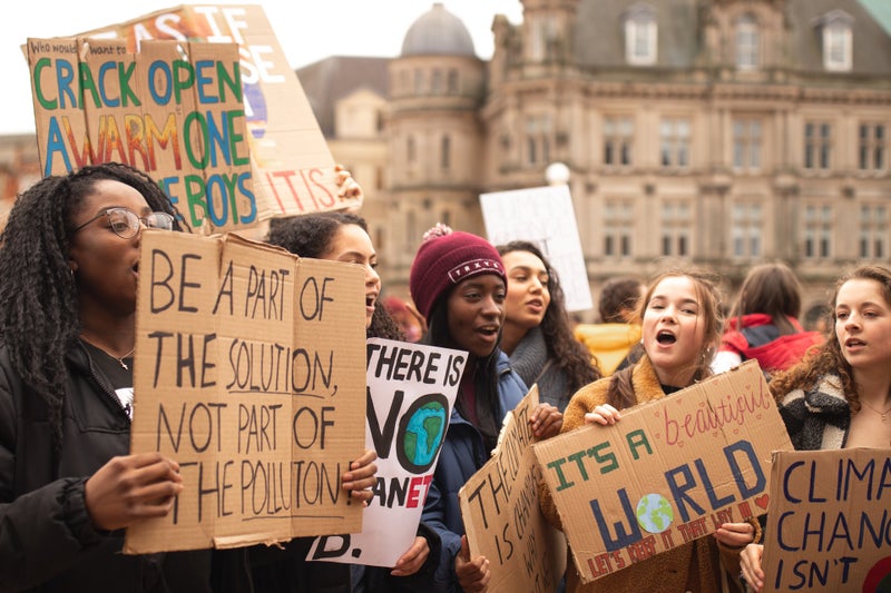 young people hold signs at a protest