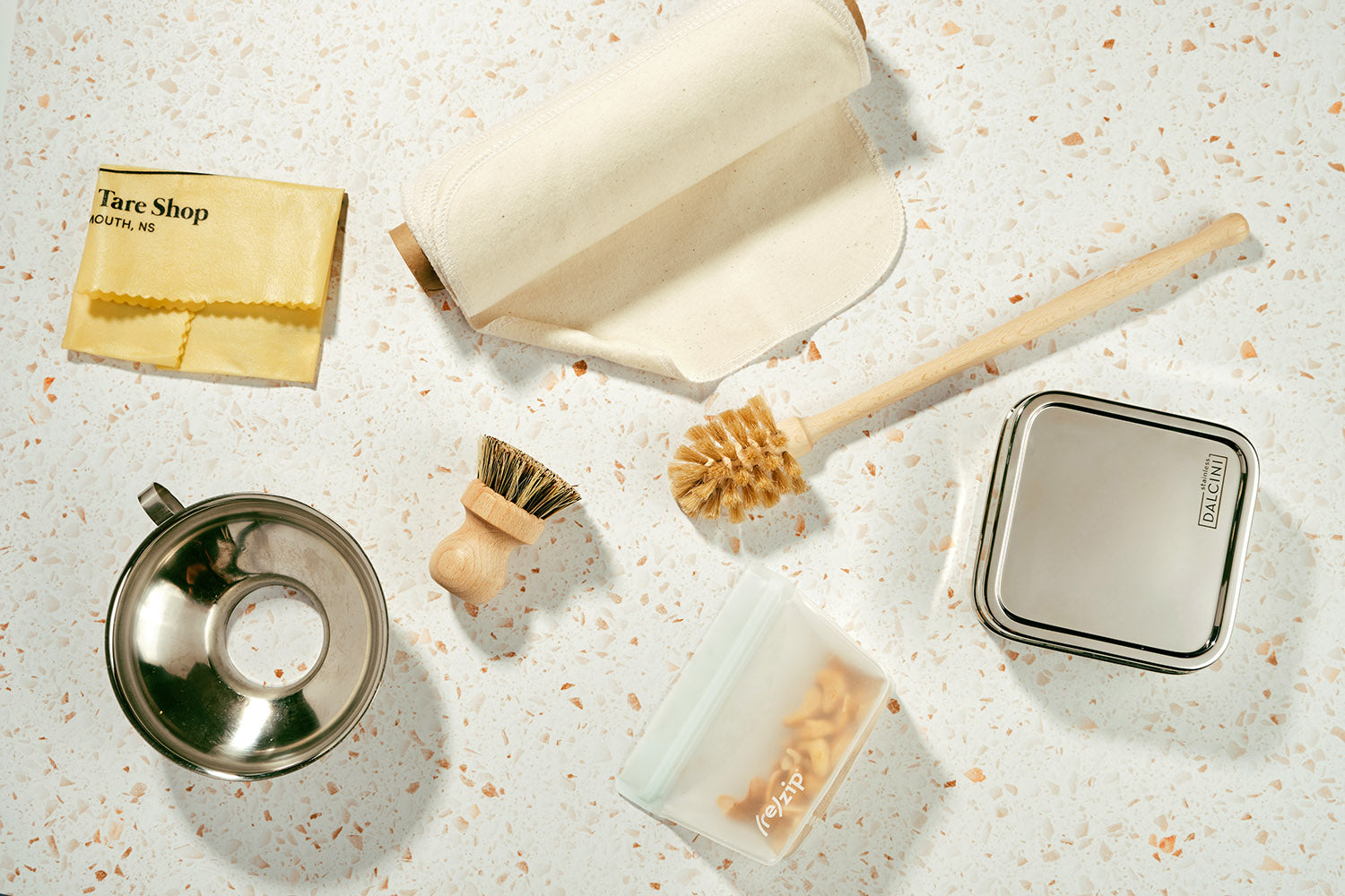 An assortment of kitchen lifestyle goods sit on a terrazzo counter.